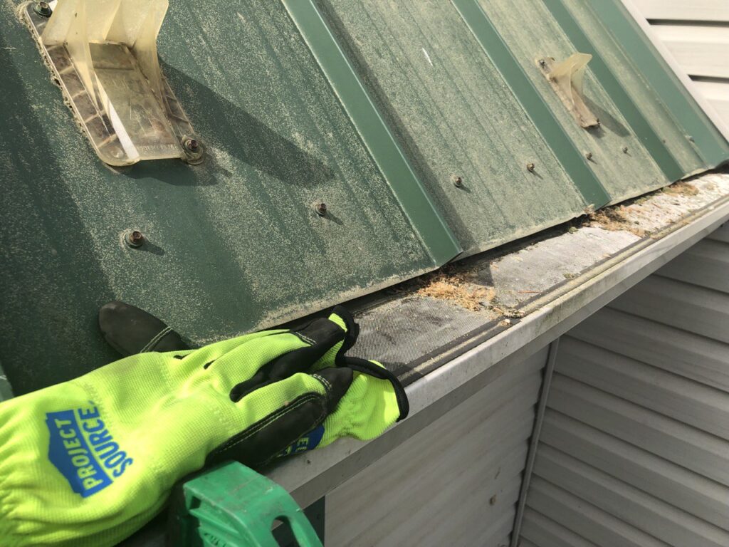 person performing winter gutter cleaning